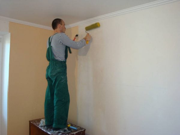 Người đàn ông sơn lót tường sau khi puttying