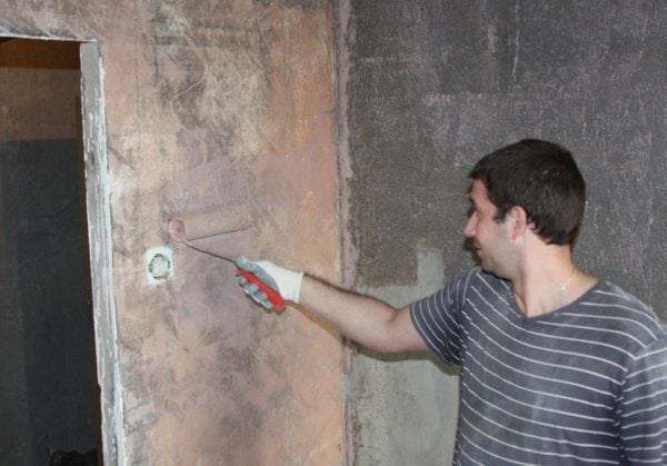 Човек поставя бетонен контакт на стената