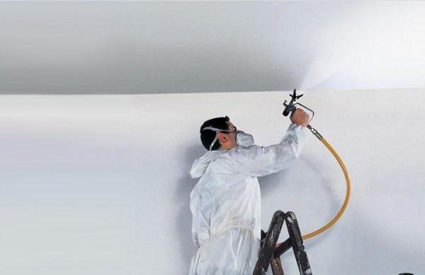 Một người đàn ông đang áp dụng sơn lót vào tường