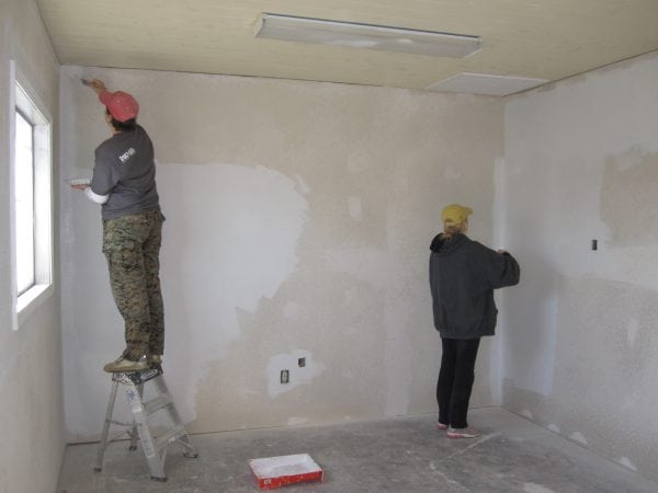 Trabalhadores preparam as paredes