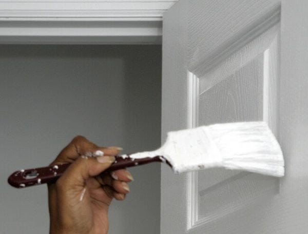 Peindre la porte avec une brosse à panneaux étroite