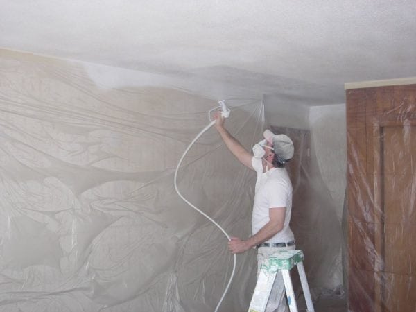 Процесът на нанасяне на боя на тавана с пистолет за пръскане