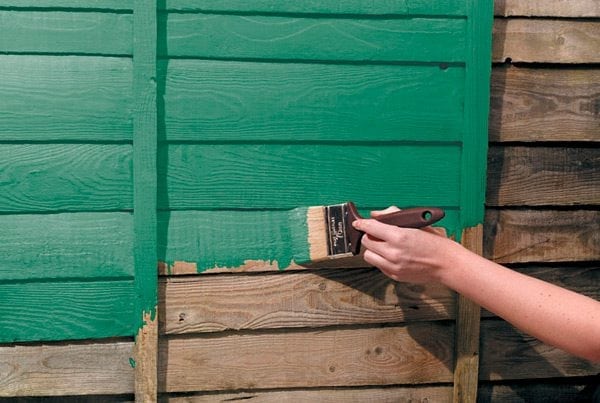 Peindre des murs en bois à l'extérieur de la maison