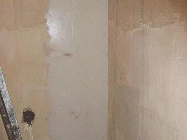 Masticage des murs d'aggloméré sous le papier peint