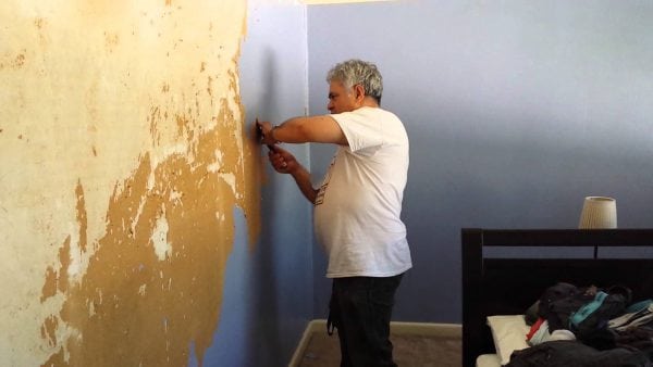 Łuszczącą się farbę należy usunąć ze ściany.