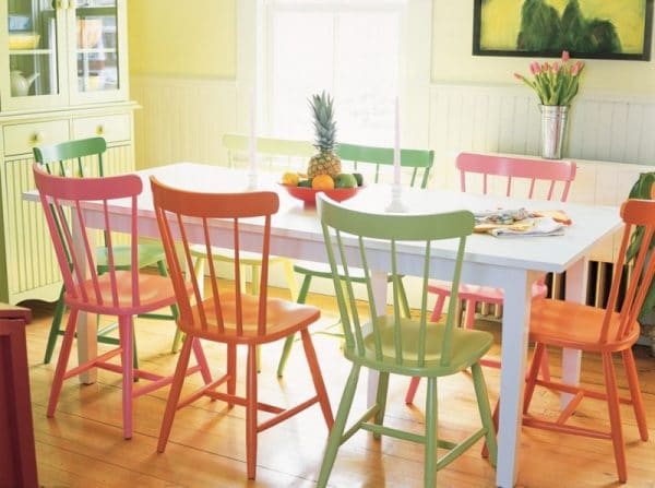 Cadeiras de madeira multicoloridas no interior da cozinha