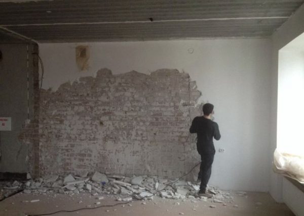 Desmontagem de gesso de uma parede de tijolos