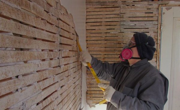 Démontage du plâtre d'un mur en bois